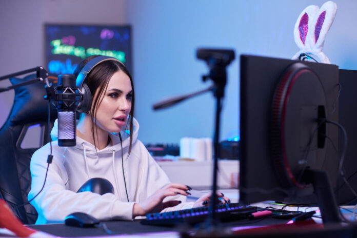 mujer-feliz-poniendose-auriculares-jugando-juegos-computadora